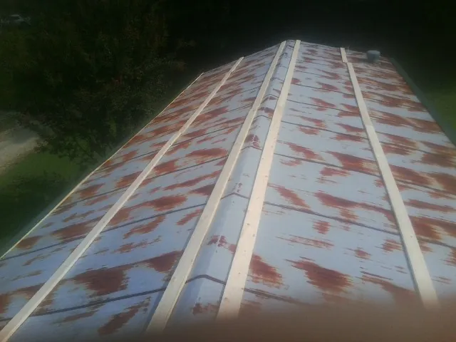 Rusted metal roof panels with new wood purlins before replacement — Storm Damage Roof Repair in New Caney by Roofing Brothers