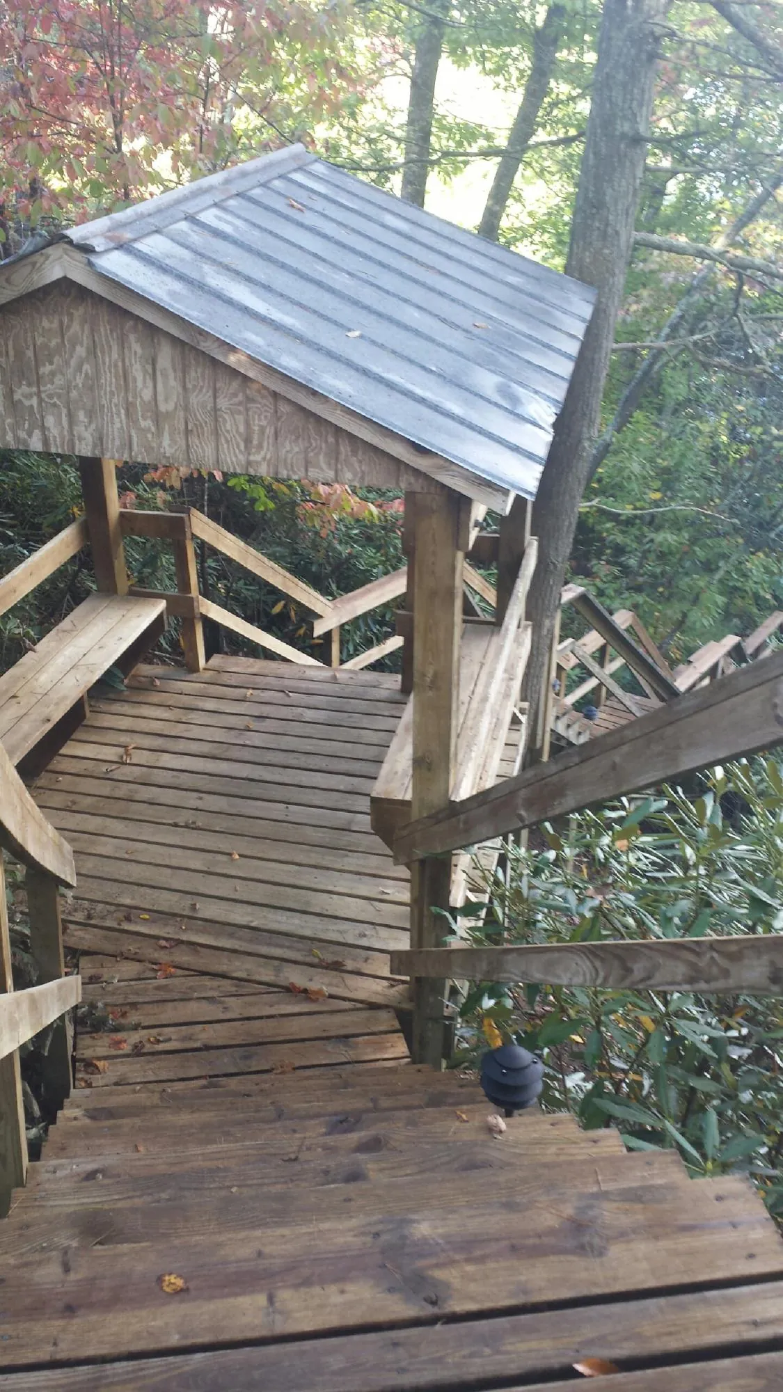 Metal roofed shelter over wooden steps on a wooded walkway — Skylight Repair & Installation work by our crew in New Caney