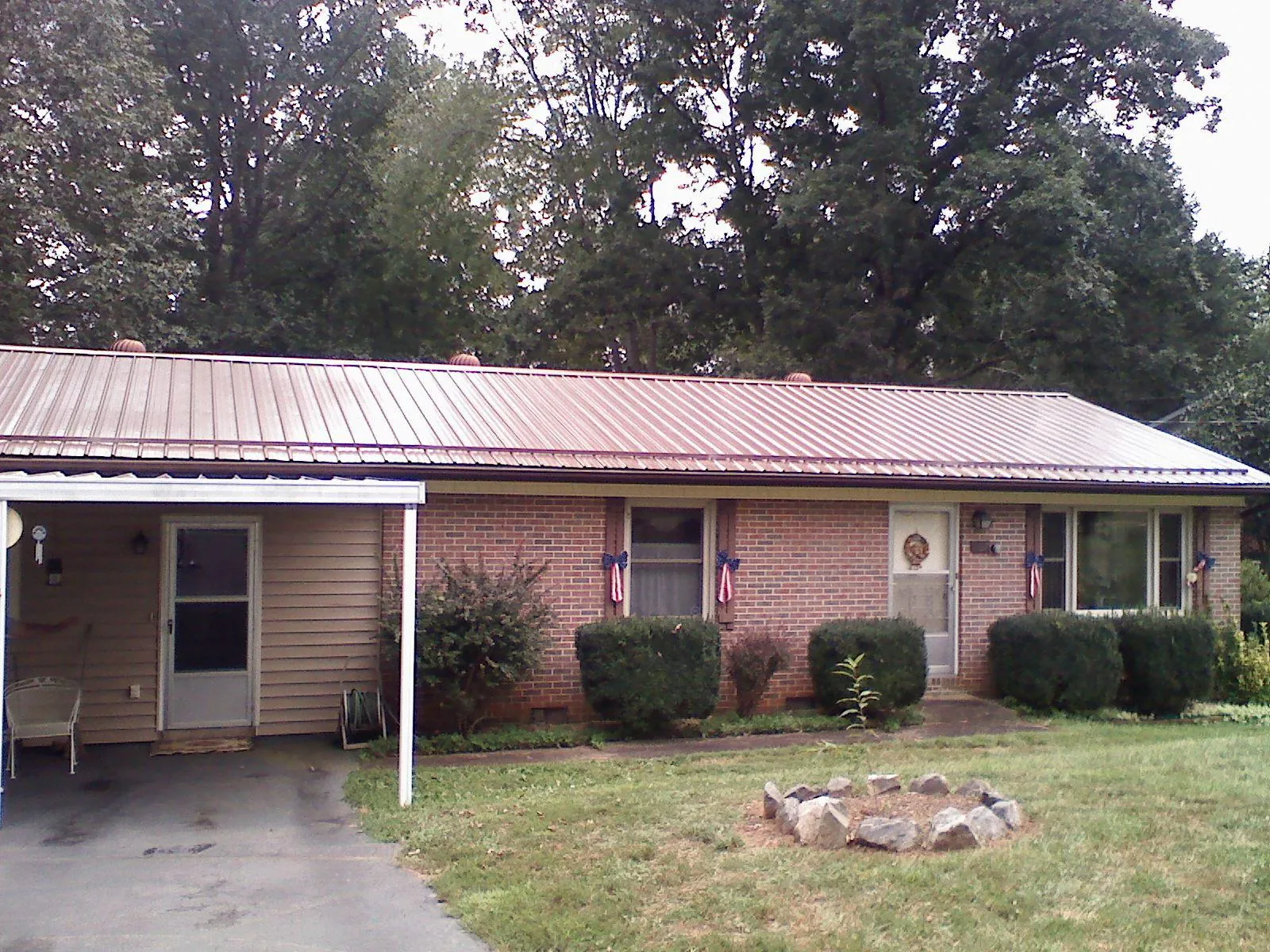 Bronze metal roof and carport on a brick ranch home — Roof Repair work by our crew in New Caney